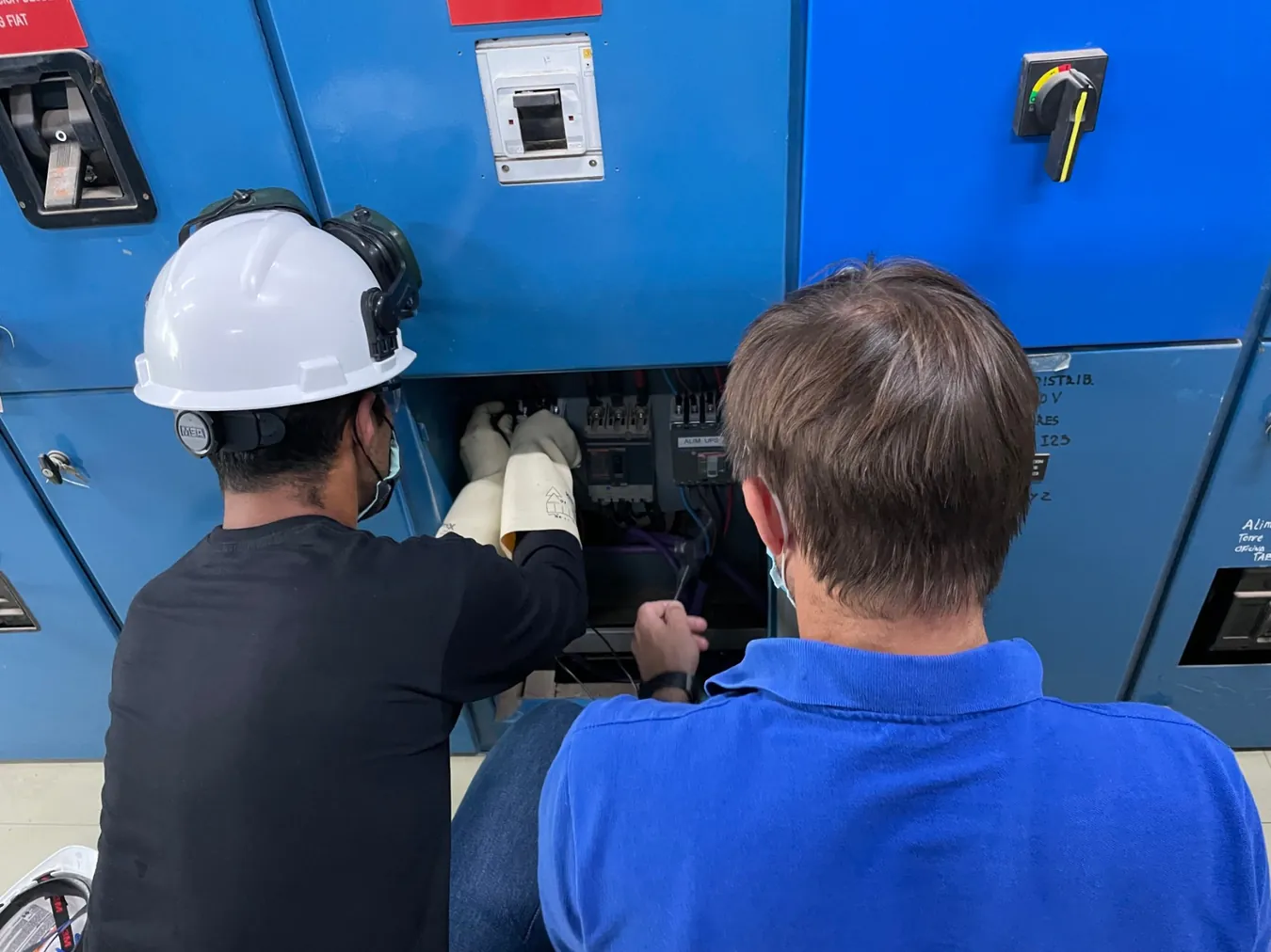 Técnicos de AMF interviniendo un tablero eléctrico en planta